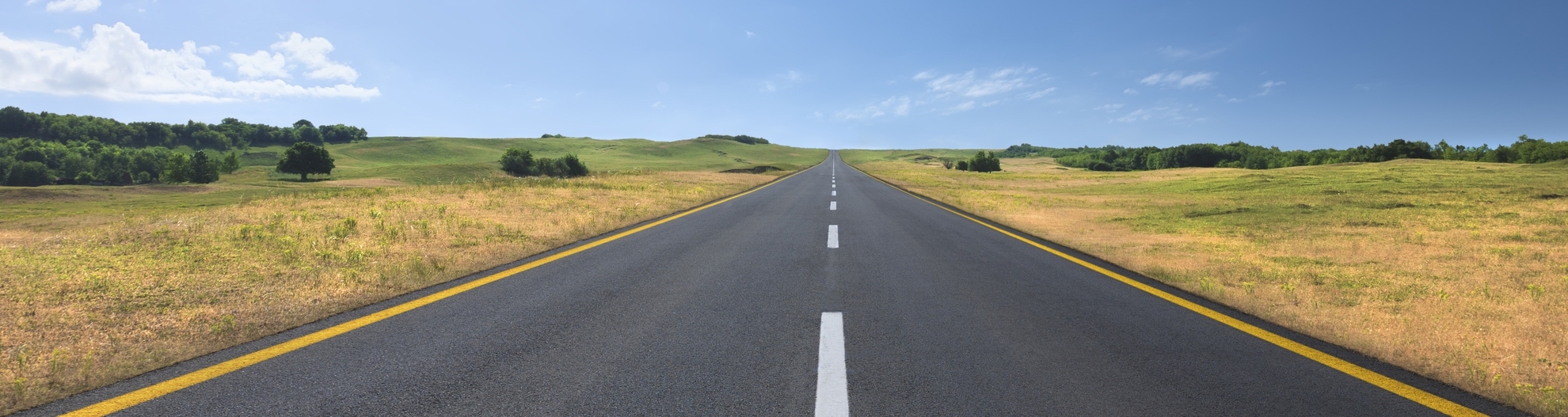 road going into flat horizon with clear skies. 