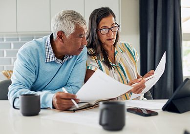 Mature couple reviewing finance documents at a table