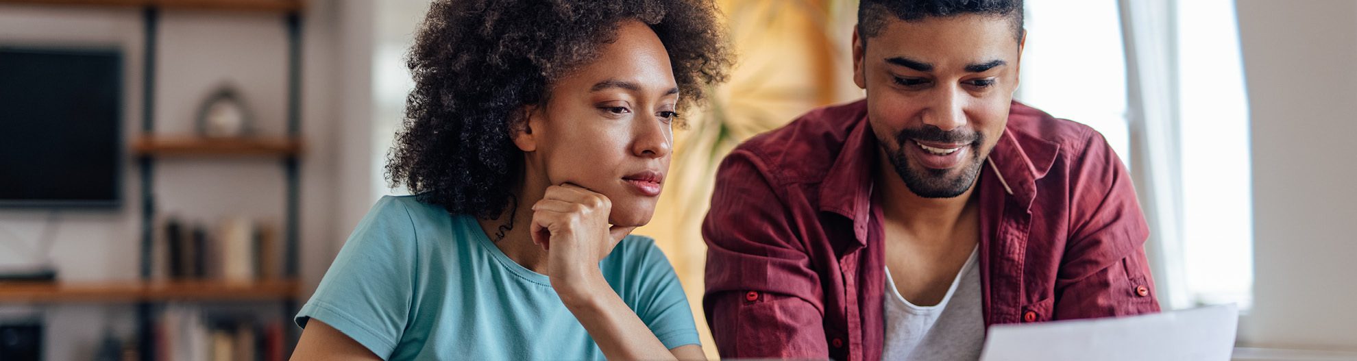 Young couple in kitchen reviewing paperwork