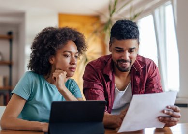 Image of young couple reviewing paperwork together in kitchen