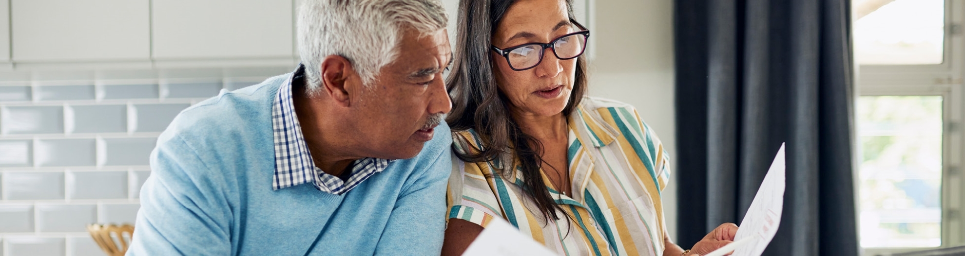 Mature couple reviewing finance documents at a table