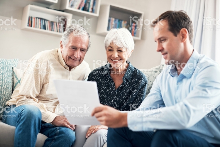 young man helping elderly couple showing piece of paper