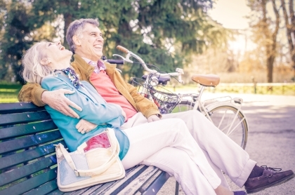 Older couple smiling on bench