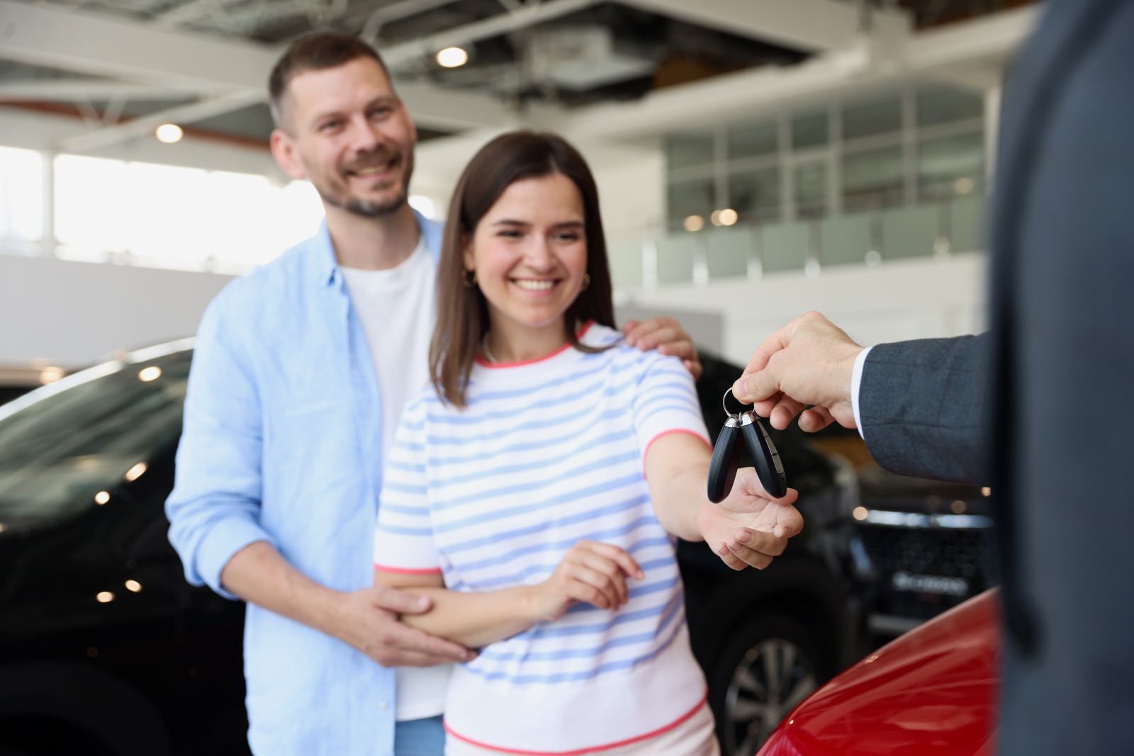 Couple getting keys to a new car