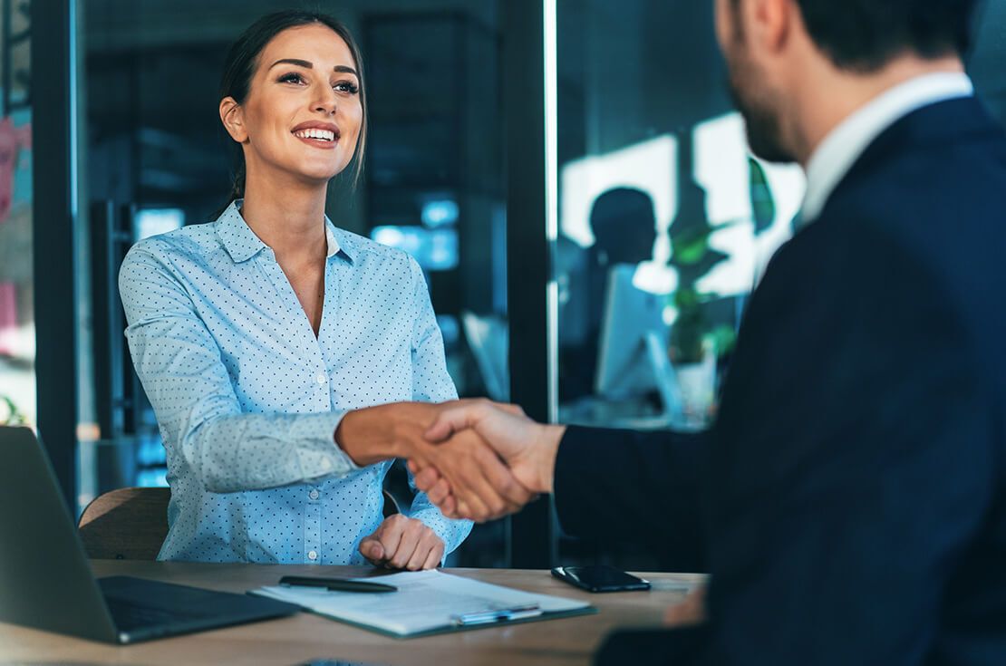 Happy Smiling young business persons shaking hands after signing a contract